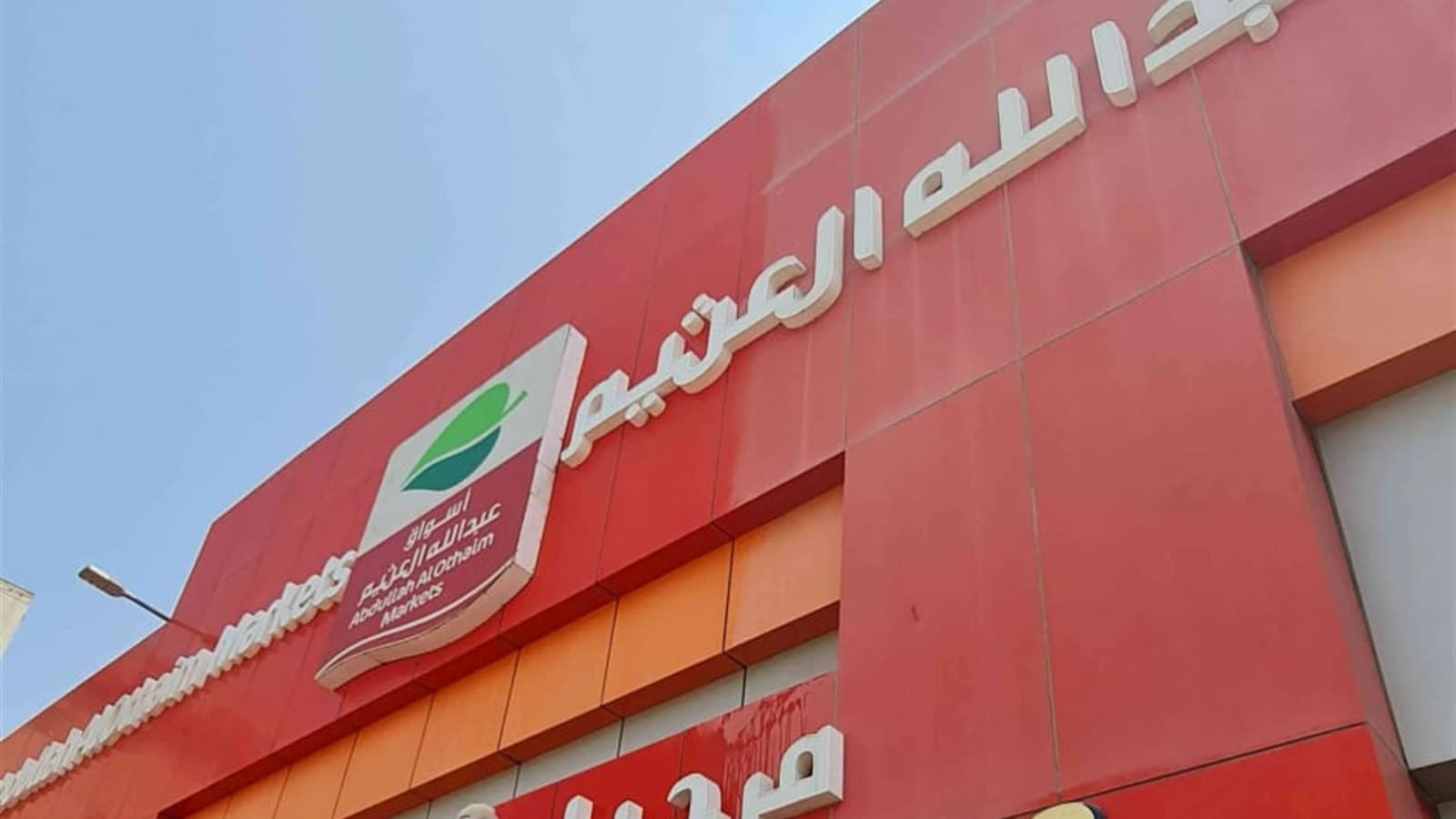 تنظيف واجهة ولوحة محل تجاري باستخدام رافعة